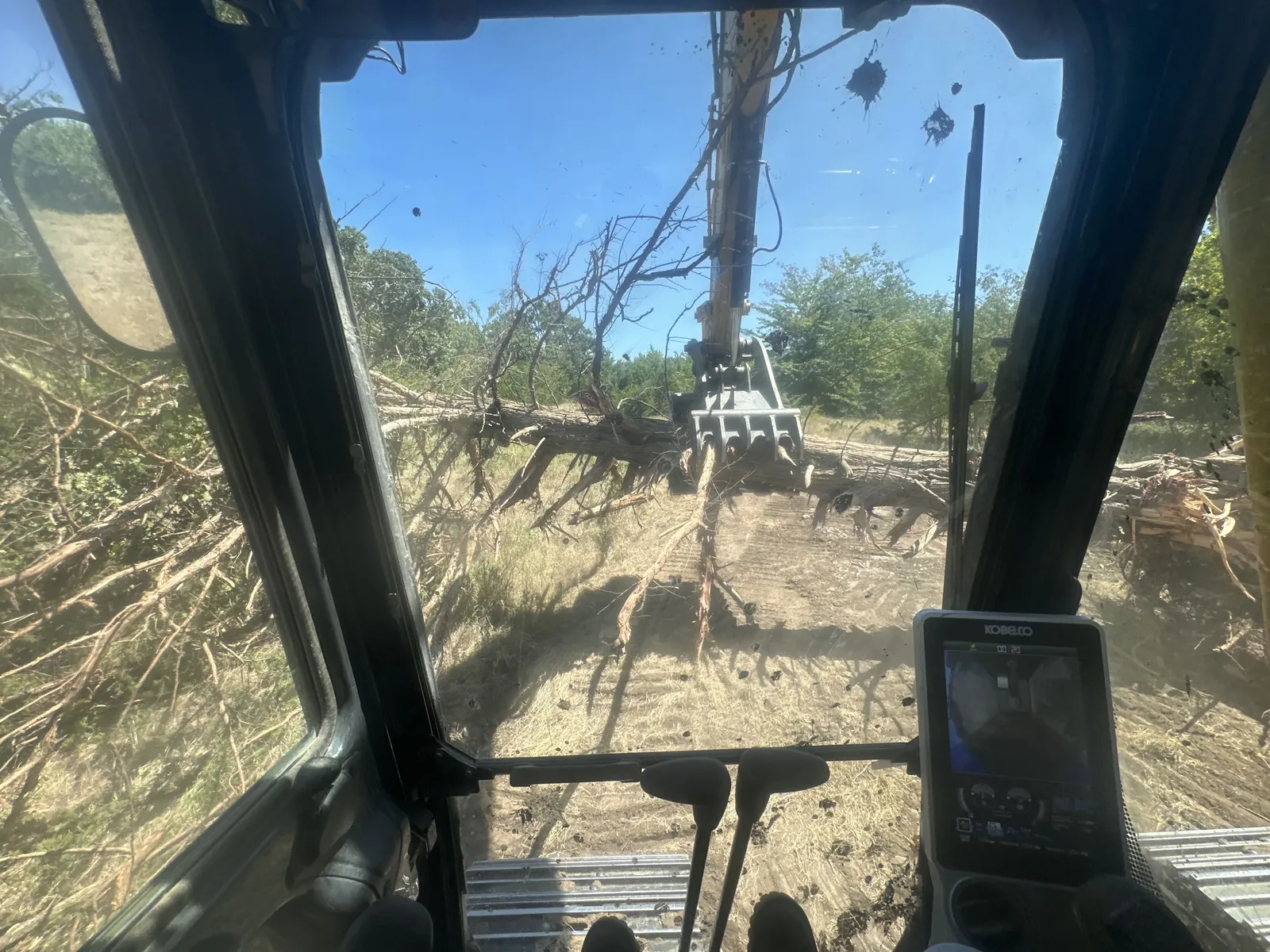 Dozer cab view pushing timber during land clearing in Oklahoma
