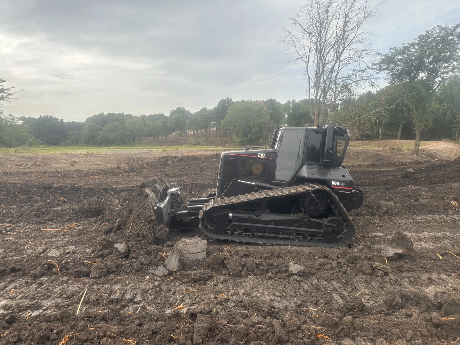 Dozer pushing dirt across an open cleared field