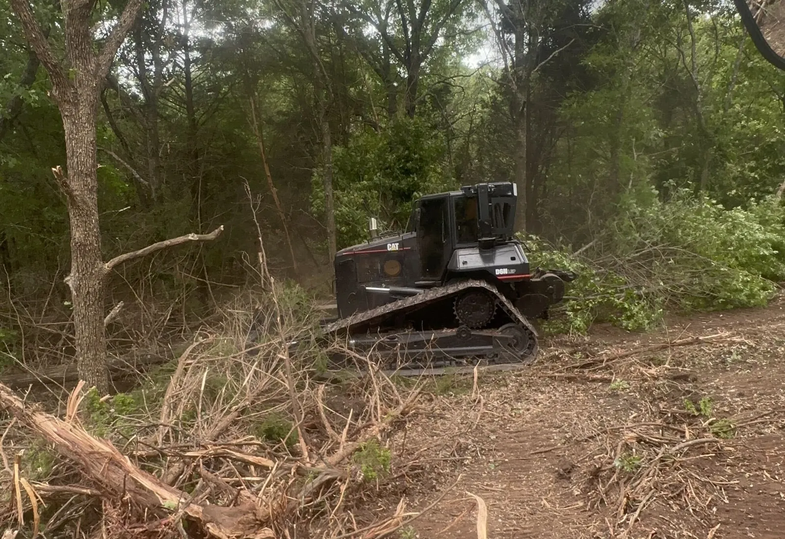 Pulled roots and stumps piled in front of the dozer on a cleared tract